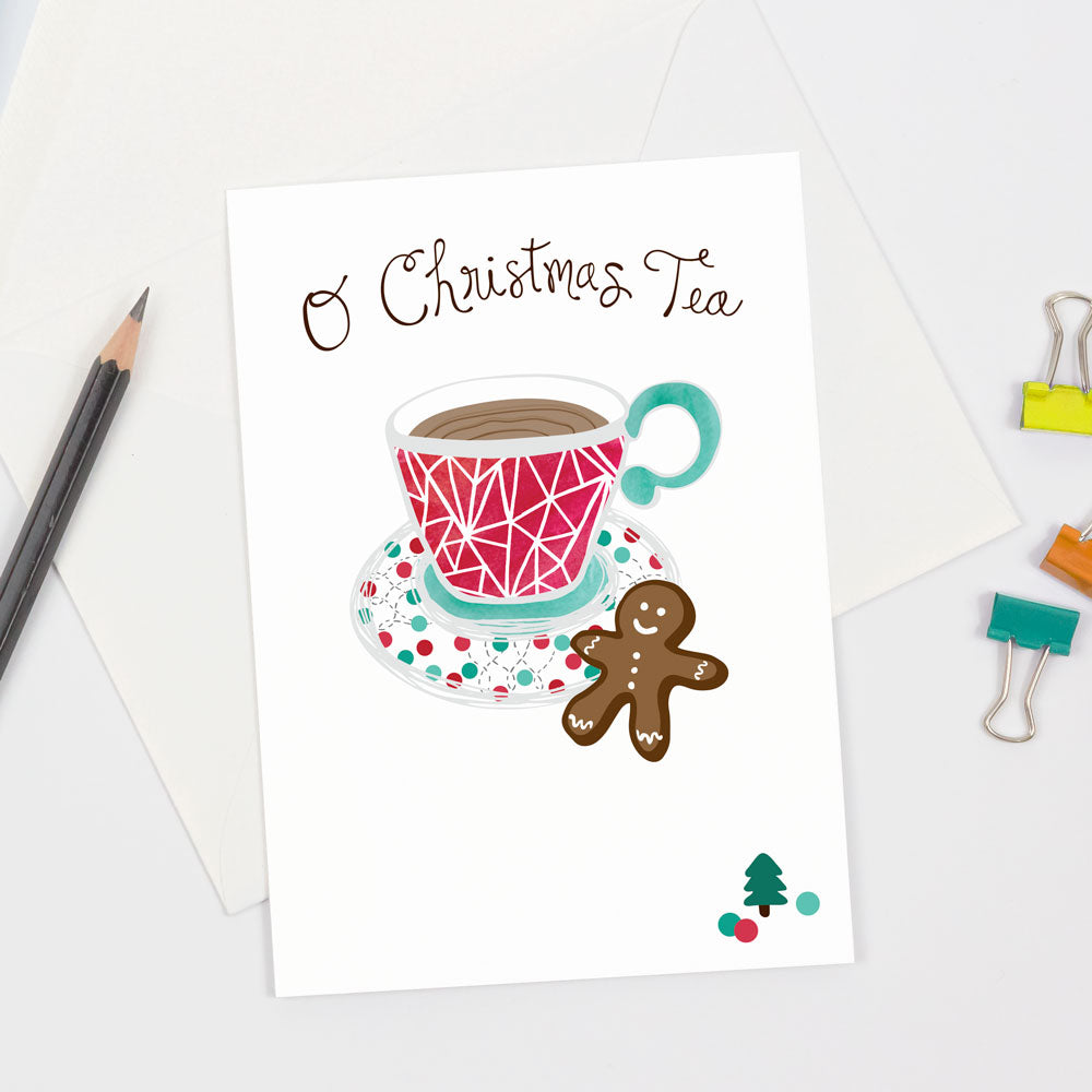 A festive Christmas greeting card featuring a ed and green teacup, a brown gingerbread cookie with handwritten "O Christmas Tea" pun text. Made in the USA by Sunny Day Designs.