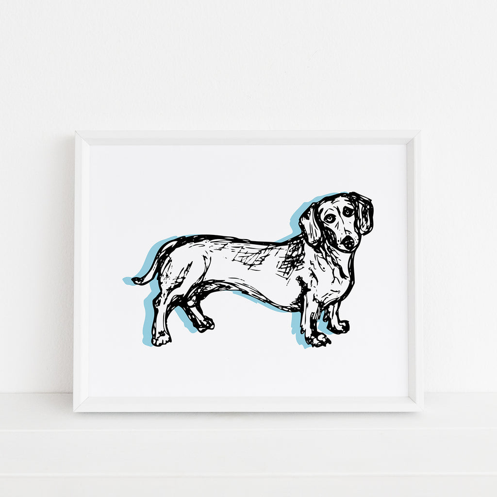 A cute illustrated dog themed 8x10 art print by Sunny Day Designs featuring an adorable sketched dachshund dog with light blue accents is printed on white watercolor paper and shown framed inside a white picture frame.