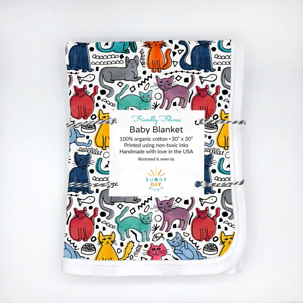 A colorful, cat themed, organic cotton printed baby blanket is packaged with baker's twine.