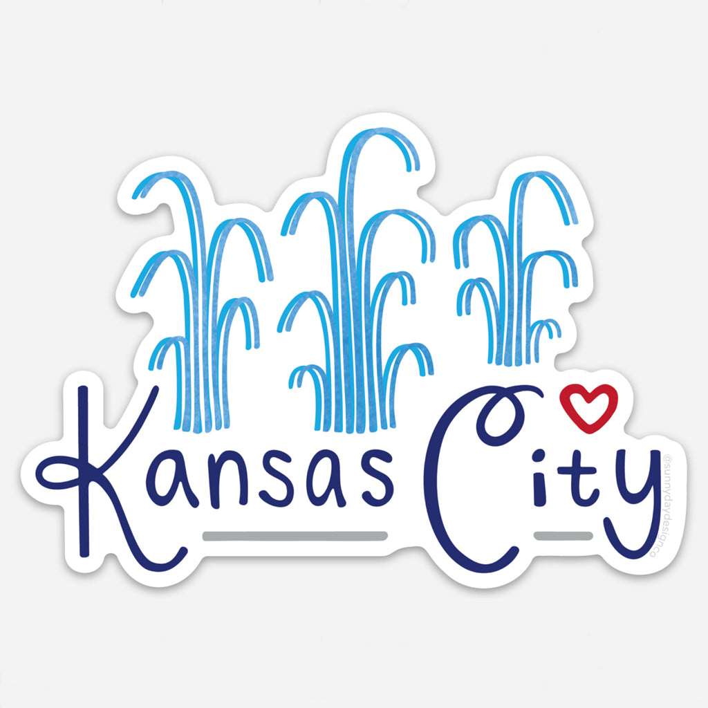 Vinyl magnet featuring stylized blue fountains above the words “Kansas City” in navy and script font with a small red heart above the “i.” Die-cut with a white border, designed by Sunny Day Designs to celebrate the City of Fountains.