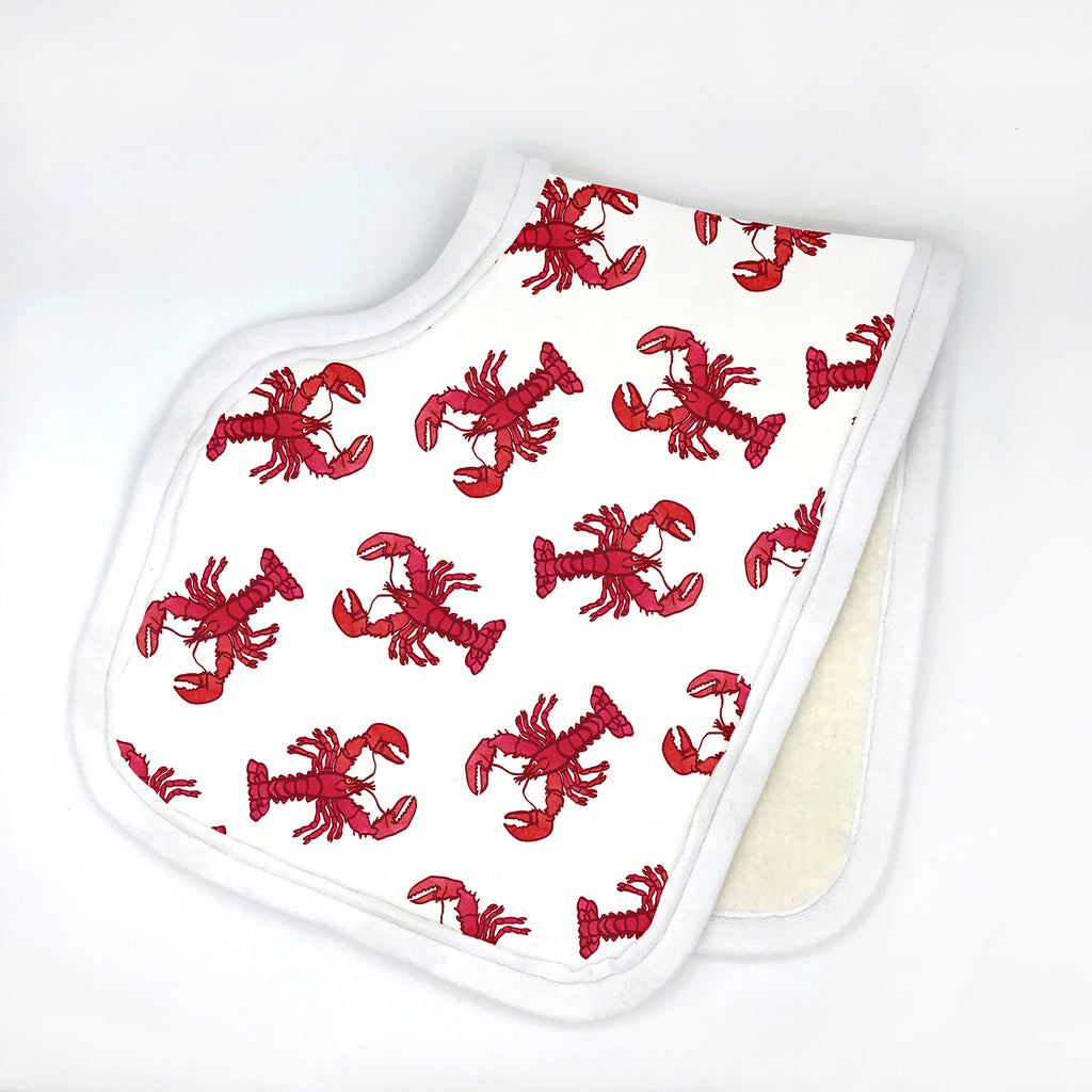 An organic cotton baby burp cloth printed with an adorable watercolor red lobster design is shown folded in half and sitting a white background. The coastal burp cloth is handmade in the USA by Sunny Day Designs from super soft organic cotton fabrics, making it a fun New England baby gift!