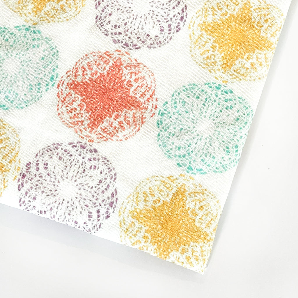 Close-up view of the Modern Mandala Tea Towel showcasing intricate, colorful circular mandala patterns in shades of yellow, orange, teal, and purple. The design is printed on a white fabric, highlighting the towel's bold, artistic aesthetic.