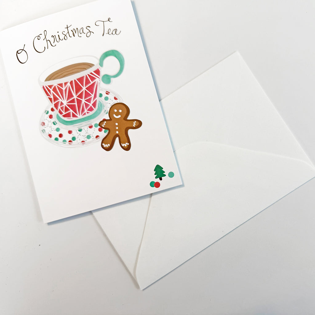 An "O Christmas Tea" holiday greeting card by Sunny Day Designs is shown on a white background and features a cute tea-themed holiday food pun alongside an illustration of a glass of tea and a gingerbread cookie.