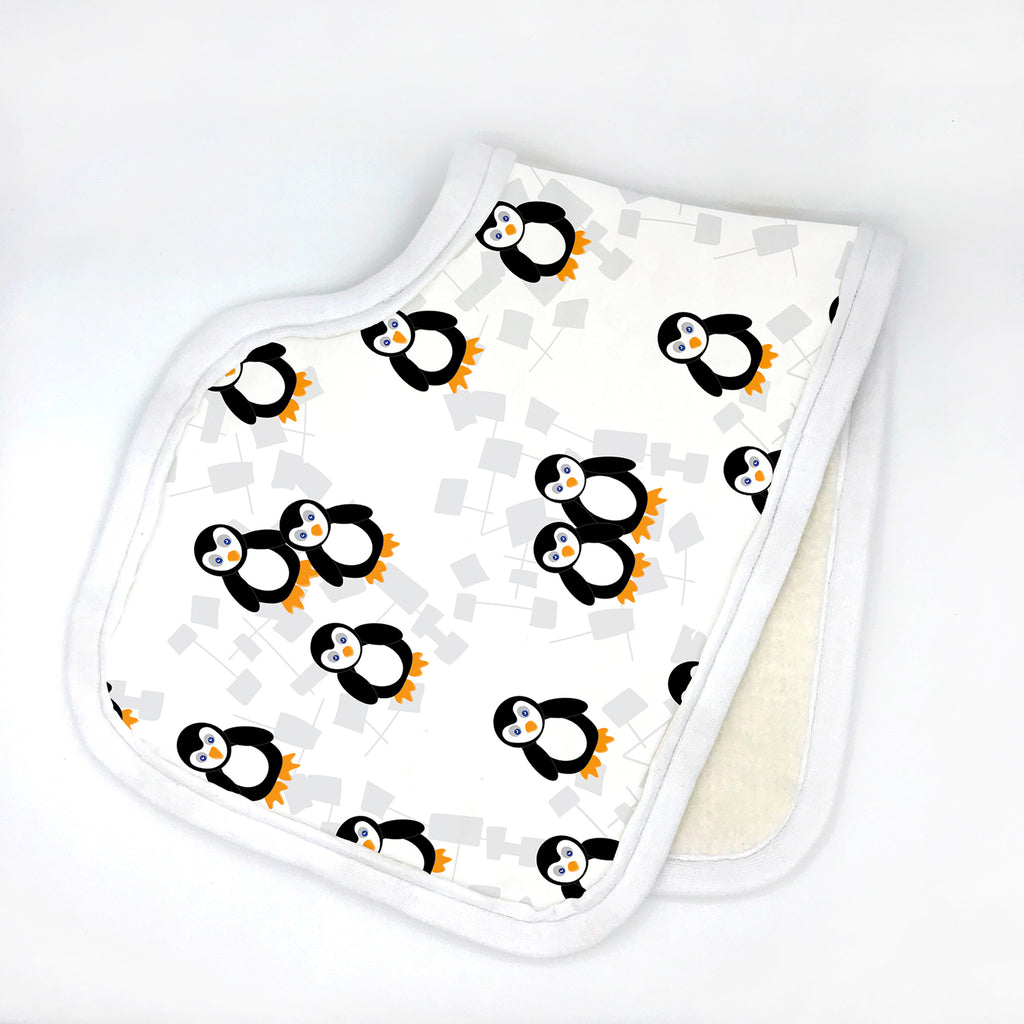 A photo of a handmade organic cotton baby burp cloth with a contoured shape is shown folded in half on a white background and is printed with a cute black, yellow, and white Playful Penguins print design. Burp cloth is made in the USA by Sunny Day Designs