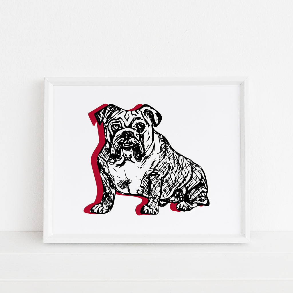 An adorable illustrated dog themed 8x10 art print featuring an adorable sketched bulldog in black with red accents is printed on white watercolor paper and shown framed inside a white picture frame. This bold black & red dog wall art makes a great UGA fan gift for students, alumni & graduates from the University of Georgia in Athens, GA, where the college mascot is the Bulldogs.