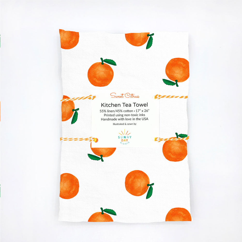 A fruit-themed kitchen tea towel printed with sweet citrus oranges on a white background. Joyfully handmade in the USA from linen/cotton fabric by Sunny Day Designs