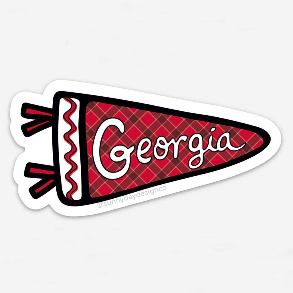 A red, black and white sports pennant-shaped thin vinyl magnet featuring the word "Georgia" in white hand lettering is shown on a white background. This cute college-themed sticker is perfect for bulldog fans, Georgia alumni & university students in Athens, GA. Each waterproof, scratch-resistant magnet is joyfully made in the USA. Designed by Sunny Day Designs in Madison, WI.