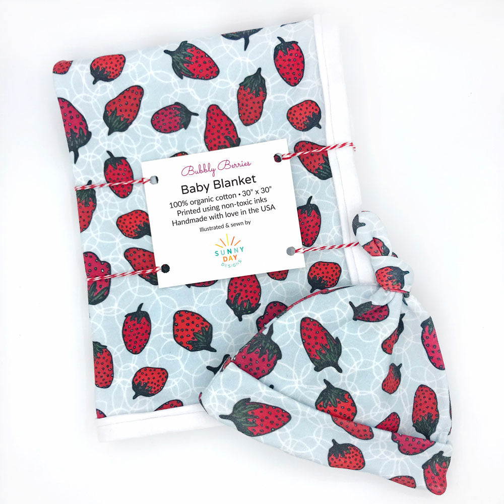 bubbly berries organic cotton baby gift set made in the USA by Sunny Day Designs with newborn hat and baby blanket in red strawberry print design with green stem on gray background