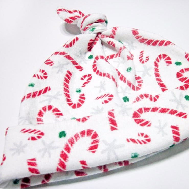 Holiday printed candy cane Christmas baby hat by Sunny Day Designs. This image is a close up of the organic cotton hat and shows the candy cane printed baby hat at a slight angle