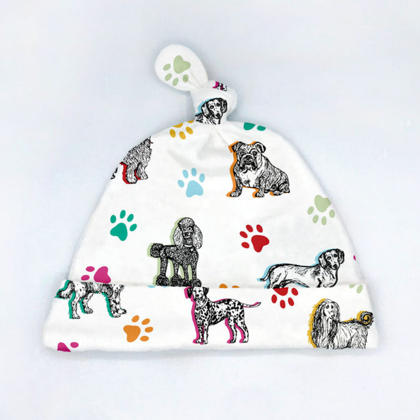 Cuddly Canines dog printed organic cotton baby hat by Sunny Day Designs features 7 cute dog breeds on a white background with colorful paw prints. Handmade in the USA.