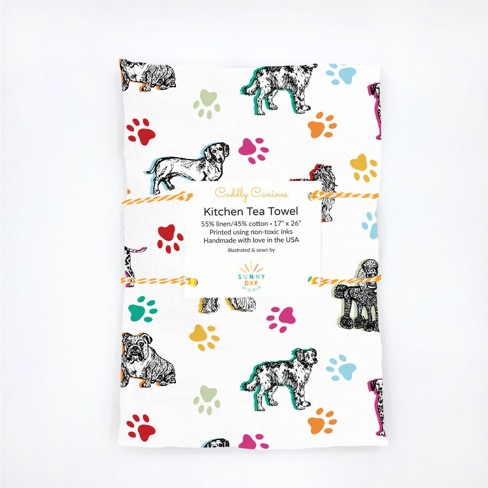 Cuddly Canines dog printed kitchen tea towel, handmade in the USA from linen/cotton fabric designed by Sunny Day Designs. This dog print features colorful dog paws and 7 illustrated dogs of the following breeds: Afghan Hound, Brittany Spaniel, Bulldog, Dachshund, Dalmatian, Poodle & Sheepdog..