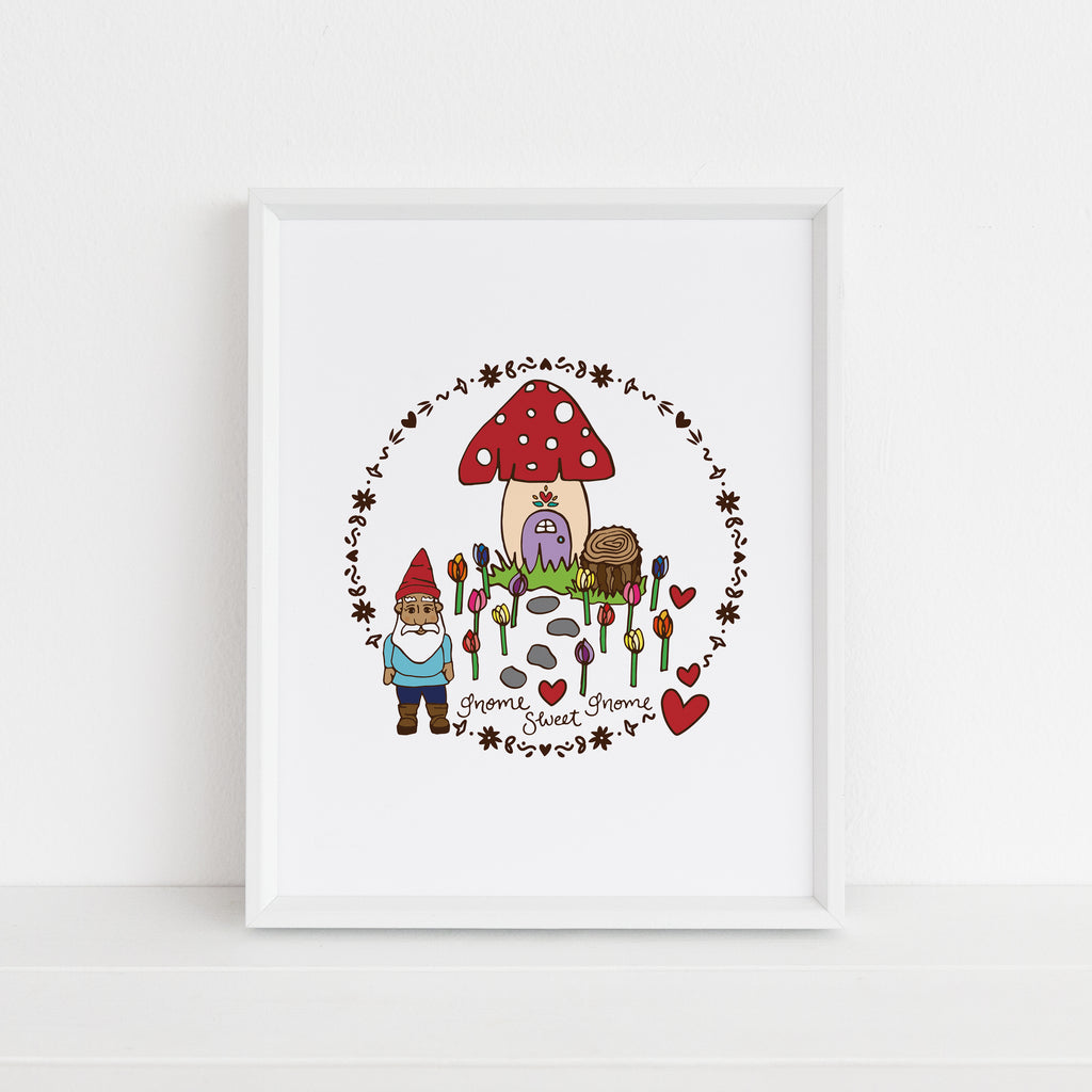 colorful garden gnome themed art print with gnome sweet gnome hand lettering, a decorative circle outline, garden of tulips, and a whimsical mushroom house. Framed in white picture frame on a white ledge and background. Print is made in the USA and designed by Sunny Day Designs