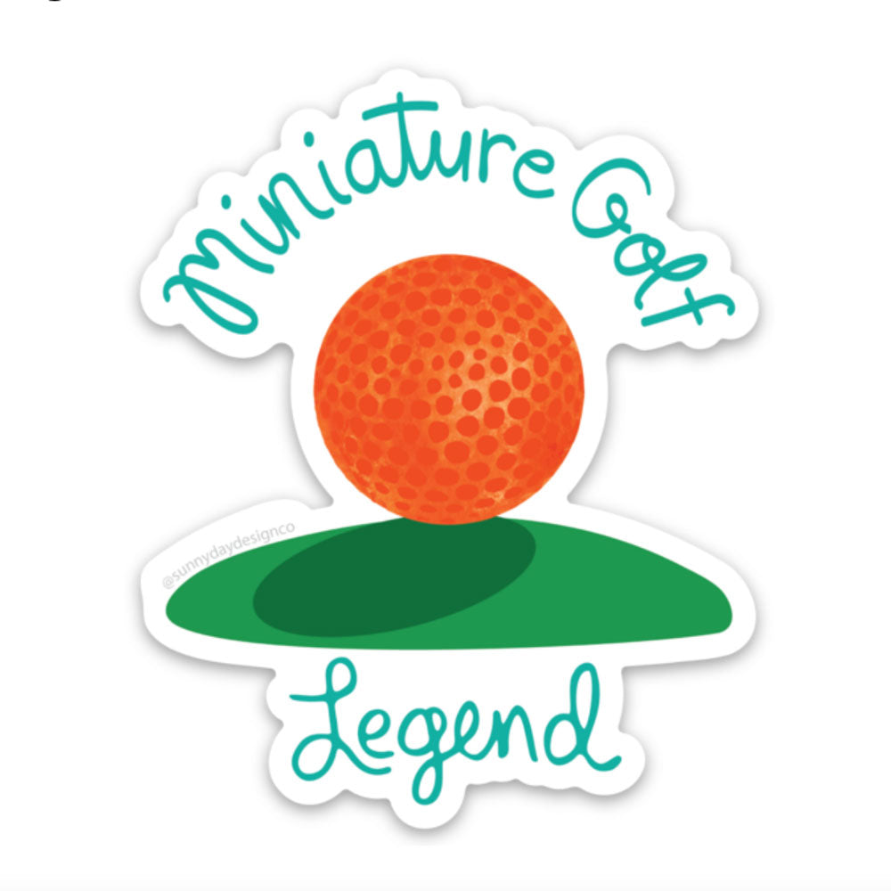 Miniature Golf Legend vinyl sticker design by Sunny Day Designs. This colorful and quirky vinyl sticker features an orange watercolor mini golf ball on a green field with turquoise "Miniature Golf Legend" hand lettered text. These fun stickers are made in the USA.