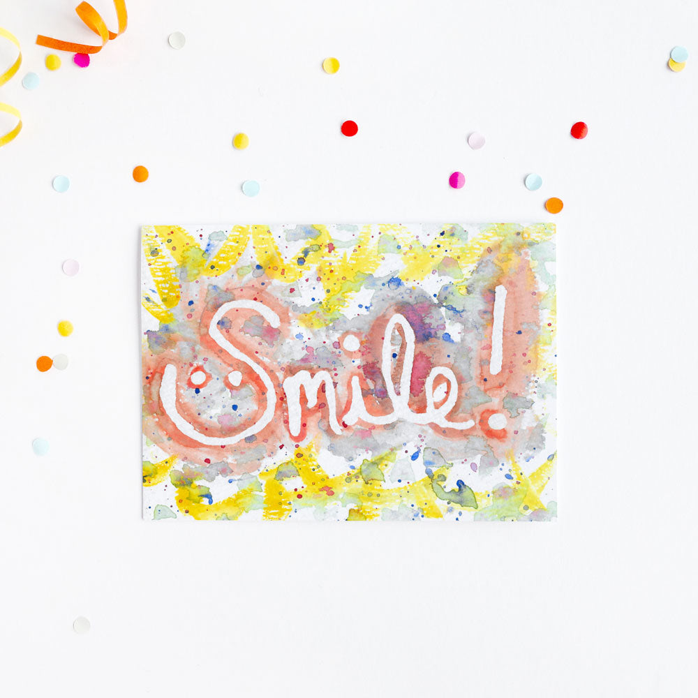 Fun greeting card with watercolor Smile text on a background with colorful confetti