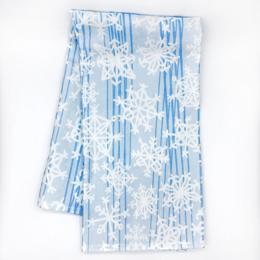 Folded blue and white Snowflake holiday tea towel by Sunny Day Designs. Photographed on white background and folded in half. Handmade in the USA and designed in Madison, WI.